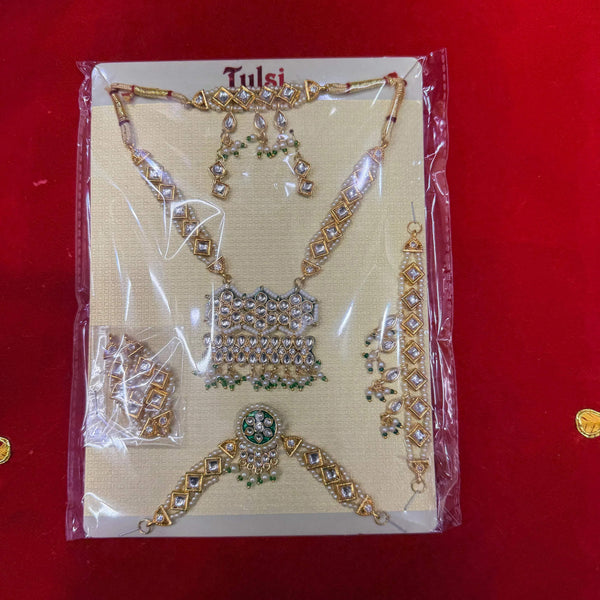 Decorative full shringar jewelry set with gold-tone kundan-style necklace and pendant pieces