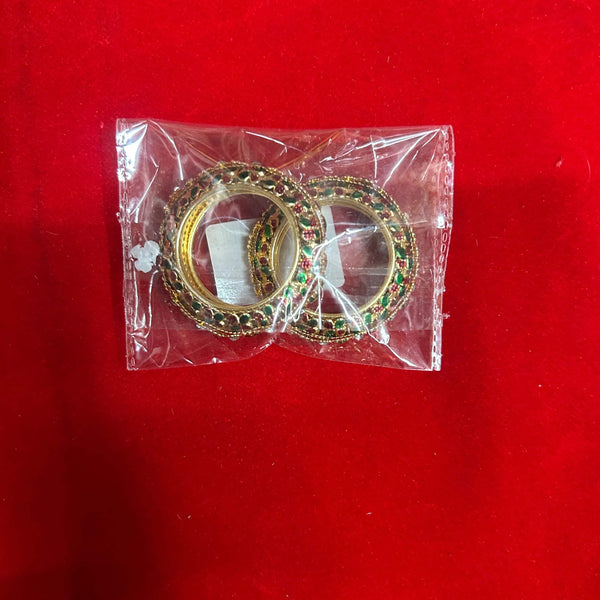 Ornate gold bangles with green stones, packed in a clear plastic sleeve