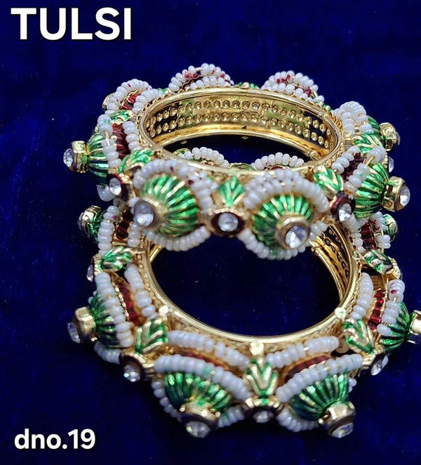 Close-up bangle ornament: gold bangle with green striped beads and white pearls