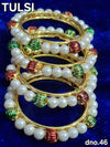 Set of gold bangles with white pearl beads and green/red striped accents