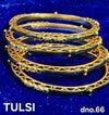 Gold-tone bangle set with green stone accents and ornate filigree details