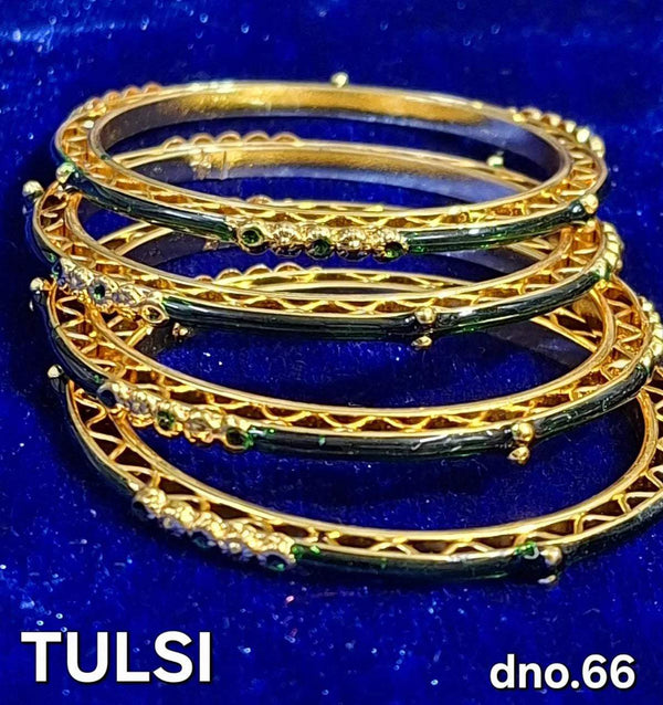 Gold-tone bangle set with green stone accents and ornate filigree details