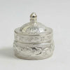 Silver thakur ji banta lidded container with engraved floral patterns