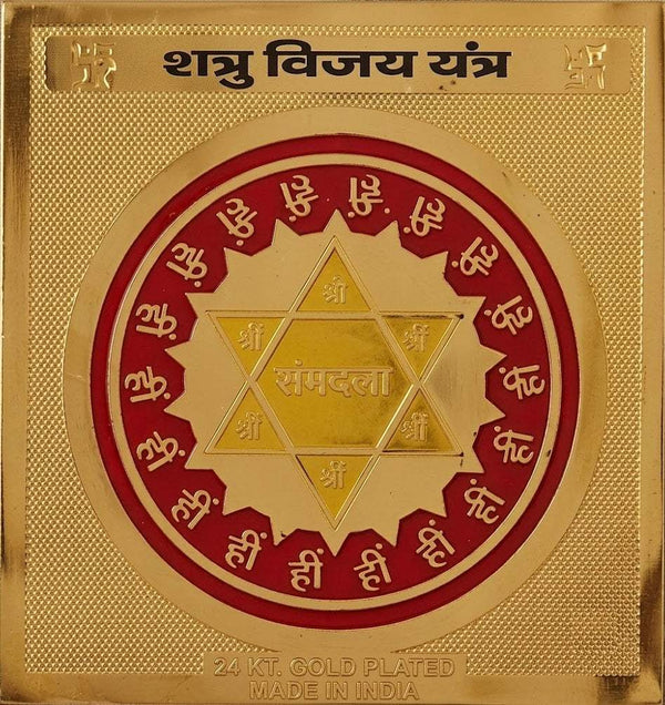 Gold plated yantra card close-up with red border and star-shaped geometric seal