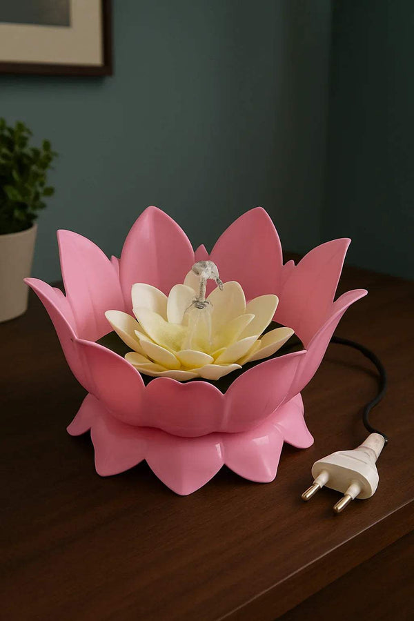 Pink lotus water fountain with pale center flower, water spout, plug-in cord on tabletop
