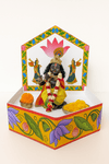 Decorative fiber boat base with bright floral panels and seated idol inside