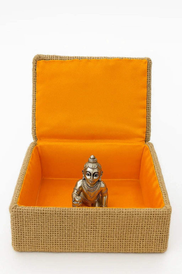 Jute idol cradle open with orange lining and small metal deity statue inside