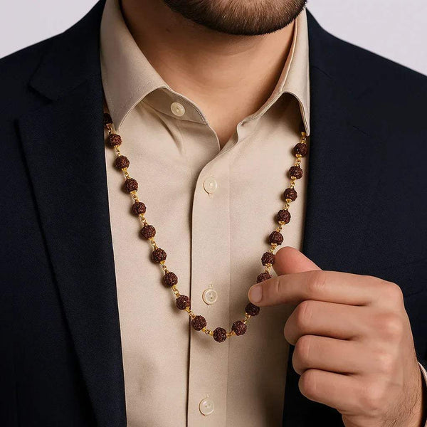 Rudraksha mala necklace draped on a shirt with brown beads and gold tone caps