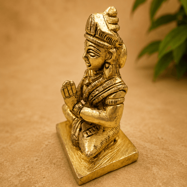 Golden Parvati meditating idol seated with hands in prayer, on a square base