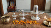 Metallic silver shivling stand with ribbed base and domed top, on tabletop