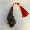 Brown digital chanting machine with compass dial, display buttons, and red tassel