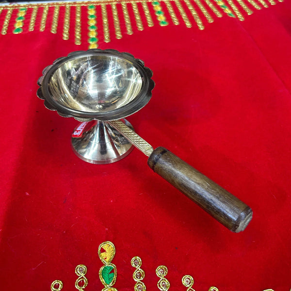 Brass dhoop stand with scalloped cup, fluted stem, and wooden handle
