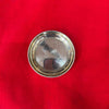 Round brass pooja plate close-up with ridged outer rim and shallow bowl