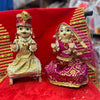 Wooden Radha-Krishna pooja idols, gold jewelry on red cloth