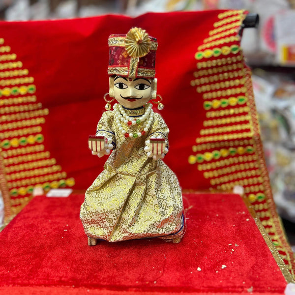Wooden deity idol figurine of Isar ji, seated with gold crown and cream patterned robe.