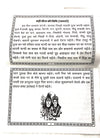 Devotional booklet open pages with Hindi text and small illustration of deities