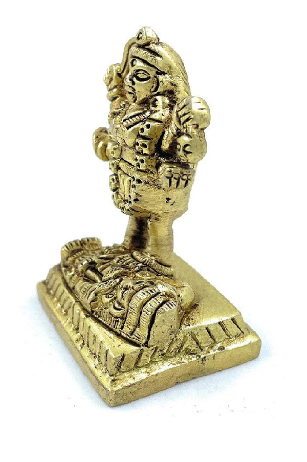 Gold-tone Kali goddess idol figurine, side view with clasped hands on pedestal
