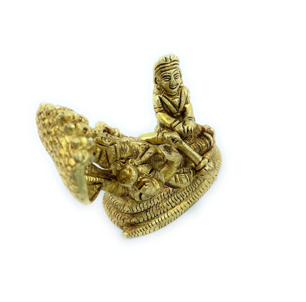 Gold-tone seated deity figurine on serpent coils with raised, flared hood behind