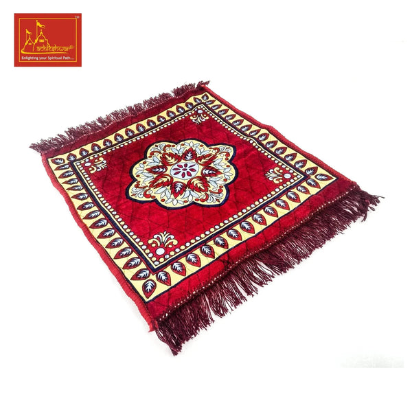 Red velvet mandir mat with ornate border, central flower rosette, corner fringe