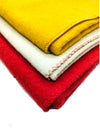 Close-up of wool pooja mats: red, white, and yellow layers with stitched edging