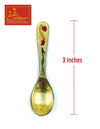 Meenakari brass serving spoon with red and green accents on leaf-like handle