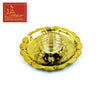 Gold tone turtle plate with central sunburst medallion and three small beaded accents