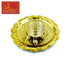 Gold tone turtle-shaped plate with central sun-and-Om medallion and three beads