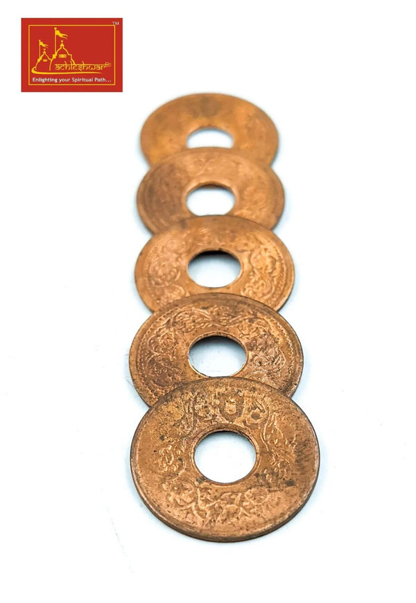 Four copper coins stacked with center holes, round discs with ornate engraving