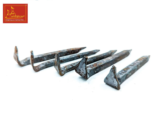 Set of 5 blue-gray metal spike nails lying down, pointed ends