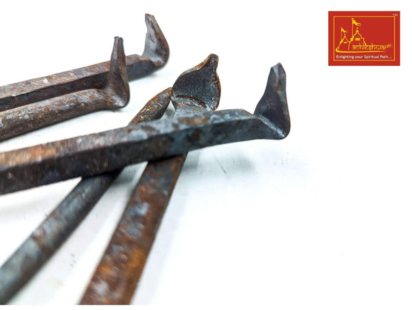 Close-up of multiple blue-gray metal spike nails with pointed tips