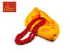 Red bead mala with orange-gold fabric pouch and printed symbols