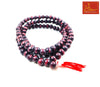 Beaded mala in a circle with dark maroon and black beads, red tassel