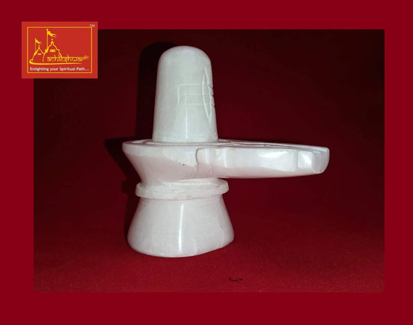 White marble Shivling with smooth cylindrical stem and wide disc arm, angled front view.
