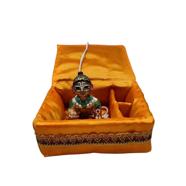 Orange decorative bal gopal cradle with embroidered trim and small deity figurine