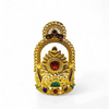 Gold-tone mukut crown with ornate filigree and round red gemstone at center