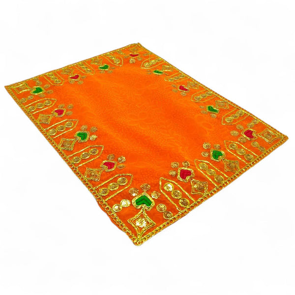 Orange velvet pooja cloth with gold embroidery and green motif accents, square