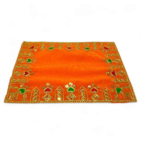 Orange velvet pooja cloth with gold border embroidery and repeating deity motifs
