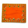 Orange velvet pooja cloth featuring gold, green, and red embroidered corner and edge designs