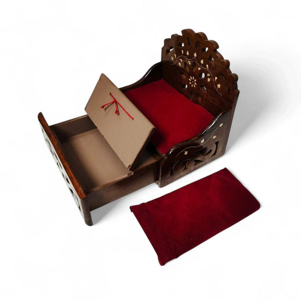 Wooden sofa cum bed with open storage tray, red cushions, and beige insert