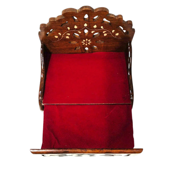 Wooden sofa cum bed with carved backrest and red cushion, back frame view