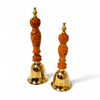 Bronze pooja bell set with two carved orange handles and gold-toned flared bells, upright