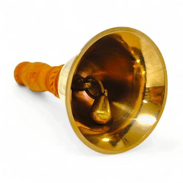 Bronze pooja bell with clapper inside and gold-toned flared mouth, handle end visible