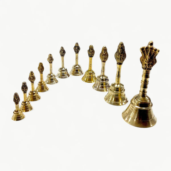 Gold brass garuda ghanti bell set viewed from an angle, bells with detailed tops