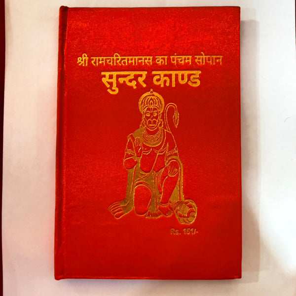 Red covered Hindu devotional book with seated deity figure on front