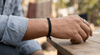 Black thread bracelet tied around wrist