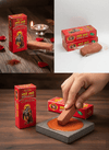 Scented tilak boxes and brown tilak slab being pressed on a stand