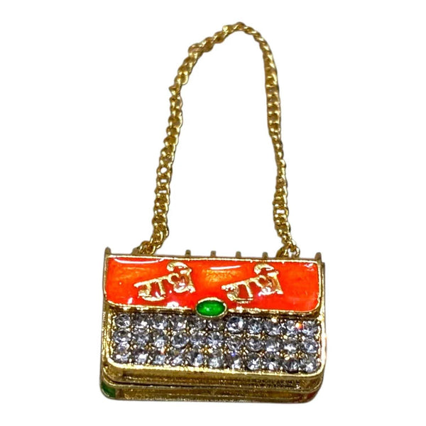 Miniature jeweled purse with orange enamel top, green gem center, gold chain handle.