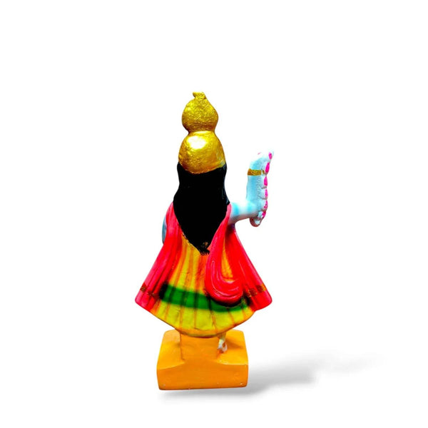 Back-view goddess statue with gold crown, multicolor red skirt, raised arm, yellow base