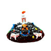Marble dust deity idol on black rocky mound with orange-capped crown, painted face and hands