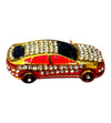 Miniature decorative toy car side view with red stripe, dark window panels, gold trim